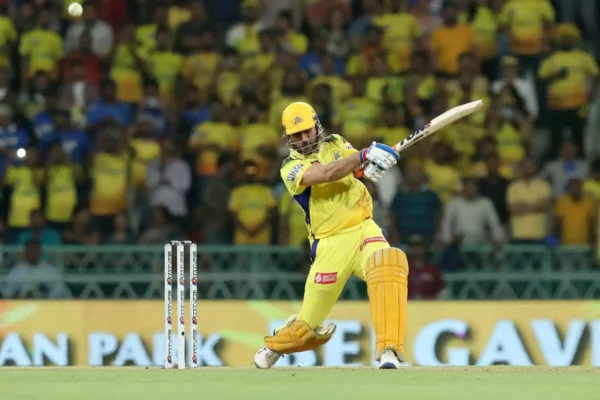 MS Dhoni wearing the CSK yellow jersey, celebrating with the IPL trophy