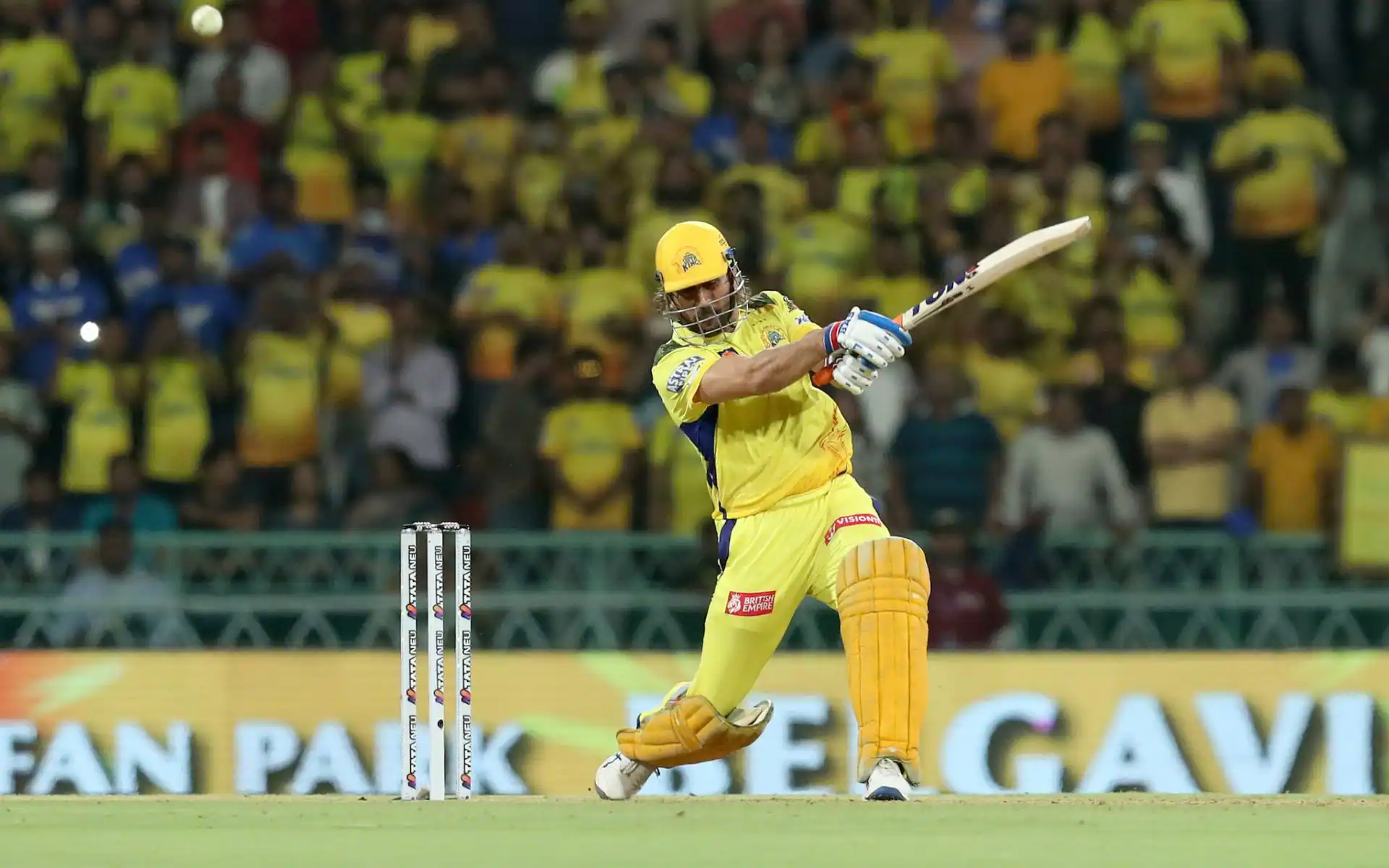 MS Dhoni wearing the CSK yellow jersey, celebrating with the IPL trophy